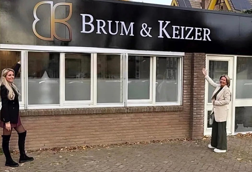 Marloes وJacqueline تلوحان أمام مبنى Brum & Keizer في Steenstraat بأولدنزال